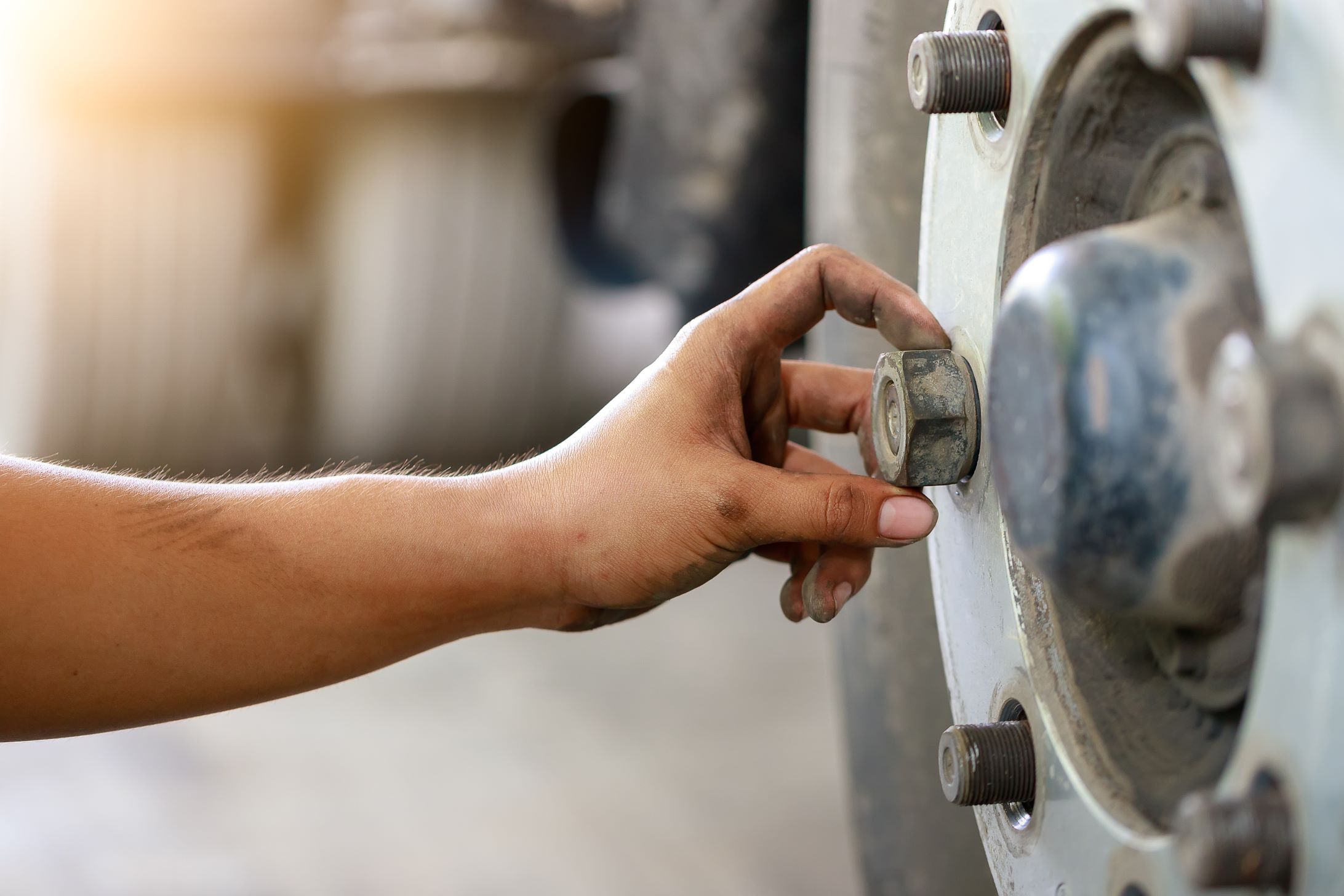 Mechanic using pneumatic gun to loosen a wheel nut 