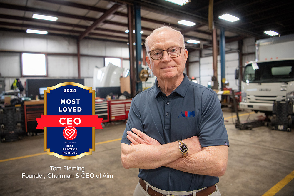 Picture of Aim founder, chairman and CEO Tom Fleming standing inside truck maintenance shop.
